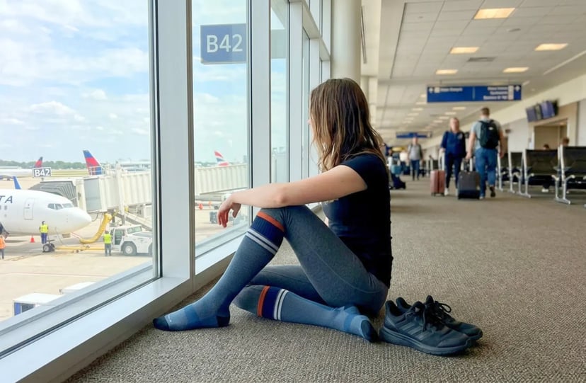 Sockwell compression socks worn in an airport departure lounge